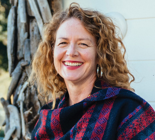 Headshot of author Suzanne Kennedy, a white woman with curly reddish-brown hair. 