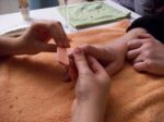 close-up of manicure being done, one hand filing another