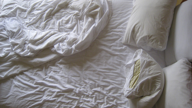 empty bed with sheets piled; not really messy, but looks slept in