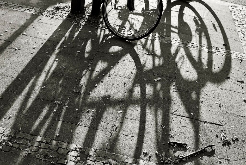 bicycle rack with shadows of wheels on pavement