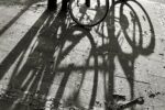 bicycle rack with shadows of wheels on pavement